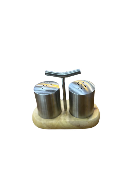 Stainless steel salt and pepper shakers on a wooden stand with a white background