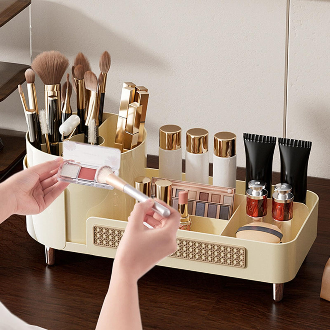 Makeup organizer with brushes and products on a reflective surface