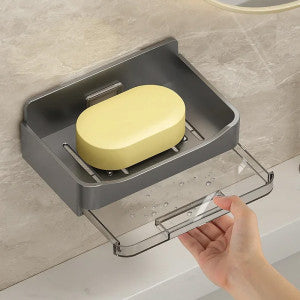 Gray soap holder with a bar of soap on a bathroom counter.